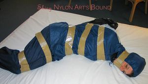 One of our archive girls bound and gagged in a blue shiny rainsuit 
