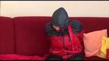 Jill tied, gagged and hooded on a sofa wearing sexy shiny black rain pants and an oldschool red/blue rain jacket (Video)