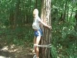 An archive girl tied and gagged on a tree by Jill both wearing shiny nylon shorts (Video)