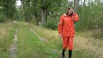 Miss Petra macht einen Spaziergang in einem orangen AGU Regenanzug und Gummistiefel