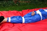 Nicole in an blue sauna suit tied and gagged in the garden (Pics)