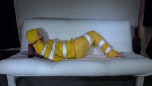 Watching Pia wearing a sexy yellow rainwear being tied and gagged with tape and a ballgag on a sofa (Video)