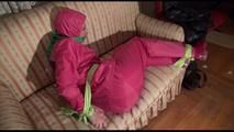 Mara tied and gagged with cloths on a sofa wearing sexy pink shiny nylon rainwear (Video)