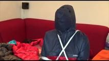 Jill tied, gagged and double hooded on a chair wearing shiny nylon shorts and two shiny nylon rain jackets (Video)