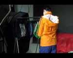 Lucy wearing a sexy blue shiny nylon pants and an orange rain jacket while folding clothes (Video)