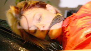 Sonja tied and gagged in bed wearing black hot shiny nylon shorts and a red rain jacket (Pics)