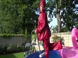 Watch Sandra watering the garden and wetting her shiny nylon oldschool Rainsuit in the Pool