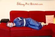 Mara tied and gagged on a sofa wearing a shiny blue PVC sauna suit (Pics)