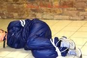 Jill tied and gagged in an old cellar on the floor wearing a shiny blue PVC sauna suit (Pics)