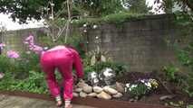 Watching Aiyana wearing supersexy pink shiny nylon rainwear while planting flowers in the garden (Video)