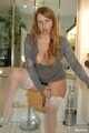 Chubby redhead Benita stripping out of a grey top and white stockings in the bathroom