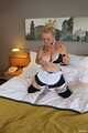 Zimmermädchen Frida posiert auf Hotelbett