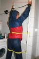 Stella tied, gagged and hooded on an radiator wearing a shiny red/blue rain combination (Pics)