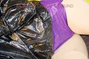 LUCY tied and gagged on a pillory in a bed wearing a supersexy selfmade purple shiny nylon shorts and a black rain jacket (Pics)