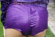 Watching sexy Aiyana wearing a sexy purple shiny nylon shorts and a purple shiny nylon rain jacket enjoying the garden shower (Pics)