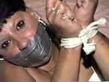 33 YEAR OLD AMERICAN INDIAN TRISH IS MOUTH STUFFED, DUCT TAPE GAGGED, BAREFOOT, & TIED UP TIGHT WITH ROPE (D64-13)