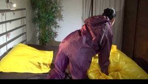 Lucy wearing a purple rain suit preparing her bed cloths for enjoying herself and the rain suit in bed lolling around (Video)