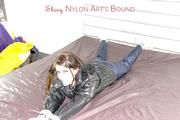 Shelly tied and gagged on a bed with downjacket and shiny rainsuit