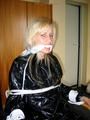 One of our archive girls tied and gagged in a shiny black PVC saunasuit
