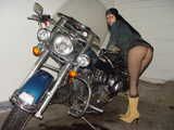 Posing on a bike in fishnets and no panties