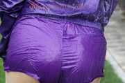 Watching sexy Aiyana wearing a sexy purple shiny nylon shorts and a purple shiny nylon rain jacket enjoying the garden shower (Pics)