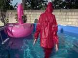 Watch Sandra watering the garden and wetting her shiny nylon oldschool Rainsuit in the Pool