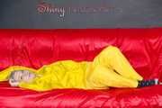 MARA wearing a sexy yellow shiny nylon rain suit lolling and posing on a bed (Pics)