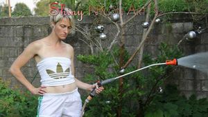 Watching sexy Sonja wearing white shiny nylon shorts and a top during watering the garden (Pisc)