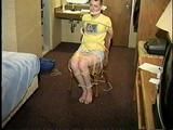 PUNK GIRL MELA IS CLEAVE GAGGED, BAREFOOT, TOE-TIED & TIED TO A CHAIR WEARING BLUE JEAN SHORTS (D63-7)