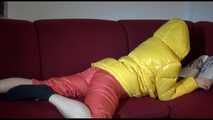 Watching sexy Lucy wearing a orange/yellow shiny nylon downwear combination reaing a magazine and lolling on the sofa (Video)