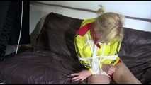PIA tied and gagged with ropes on a sofa wearing a sexy red shiny nylon shorts and a yellow rain jacket (Video)