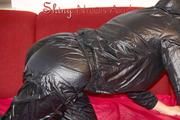 Lucy wearing a very hot black rainwear combination lolling and posing on a sofa (Pics)