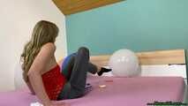 sitpopping nine U16 balloons on the bed