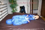 Jill tied, gagged and hooded on bed wearing a supersexy supershiny lightblue downwear (Pics)