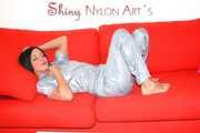 ENNI putting on a very sexy grey shiny nylon adidas rain catsuit and lolling and posing on a sofa (Pics)