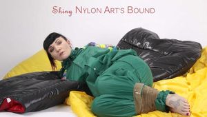 Jill tied and gagged with tape on bed wearing a shiny green nylon rainsuit (Pics)