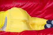 MARA wearing a sexy yellow shiny nylon rain suit lolling and posing on a bed (Pics)