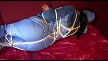 Lucy tied and gagged with a long rope on a sofa wearing a sexy oldschool skibib in blue (Video)