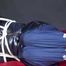 Watching Sonja wearing a supersexy black shiny nylon down jacket and a blue shiny nylon rain pants being tied, gagged and hooded with ropes  and a clothgag on a bed (Video)