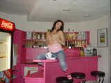 Posing and stripping on a bar