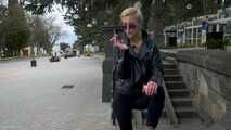 Short cut hair blonde girl is smoking two cork cigarettes