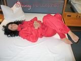 Brown-haired archive girl lolling on bed wearing a supersexy red shiny nylon rainwear combination (Pics)