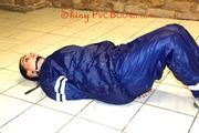 Jill tied and gagged in an old cellar on the floor wearing a shiny blue PVC sauna suit (Pics)