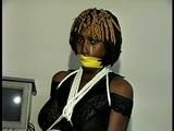 21 Yr OLD BLACK COLLEGE STUDENT GETS MOUTH STUFFED, WRAP TAPE GAGGED WHILE TIED TO A CHAIR  WEARING BLACK LINGERIE, GARTER BELT & HIGH HEELS (D65-4)