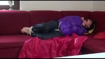 Jill tied and gagged on a red sofa wearing a black shiny nylon rain pants and a shiny down jacket (Video) 