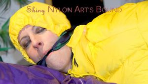 Pia wearing a sexy black rain pants and a yellow down jacket tied on bed with cuffs and gagged with a cloth (Pics)