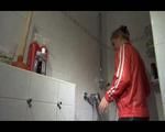 Mara wearing a very special red rain jacket and a darkblue rain pants enjoying herself and the cloths during taking a shower in it (Video)