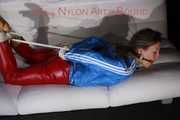 SEXY SANDRA being tied and gagged with ropes and a ballgag on a sofa wearing a SUPERSHINY NEW RED NYLON PANTS and a rain jacket (Pics)