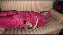 Mara tied and gagged with cloths on a sofa wearing sexy pink shiny nylon rainwear (Video)