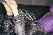 Sandra tied and gagged on a sofa with cuffs and a pillory wearing hot purple down jacket and black down pants (Pics)